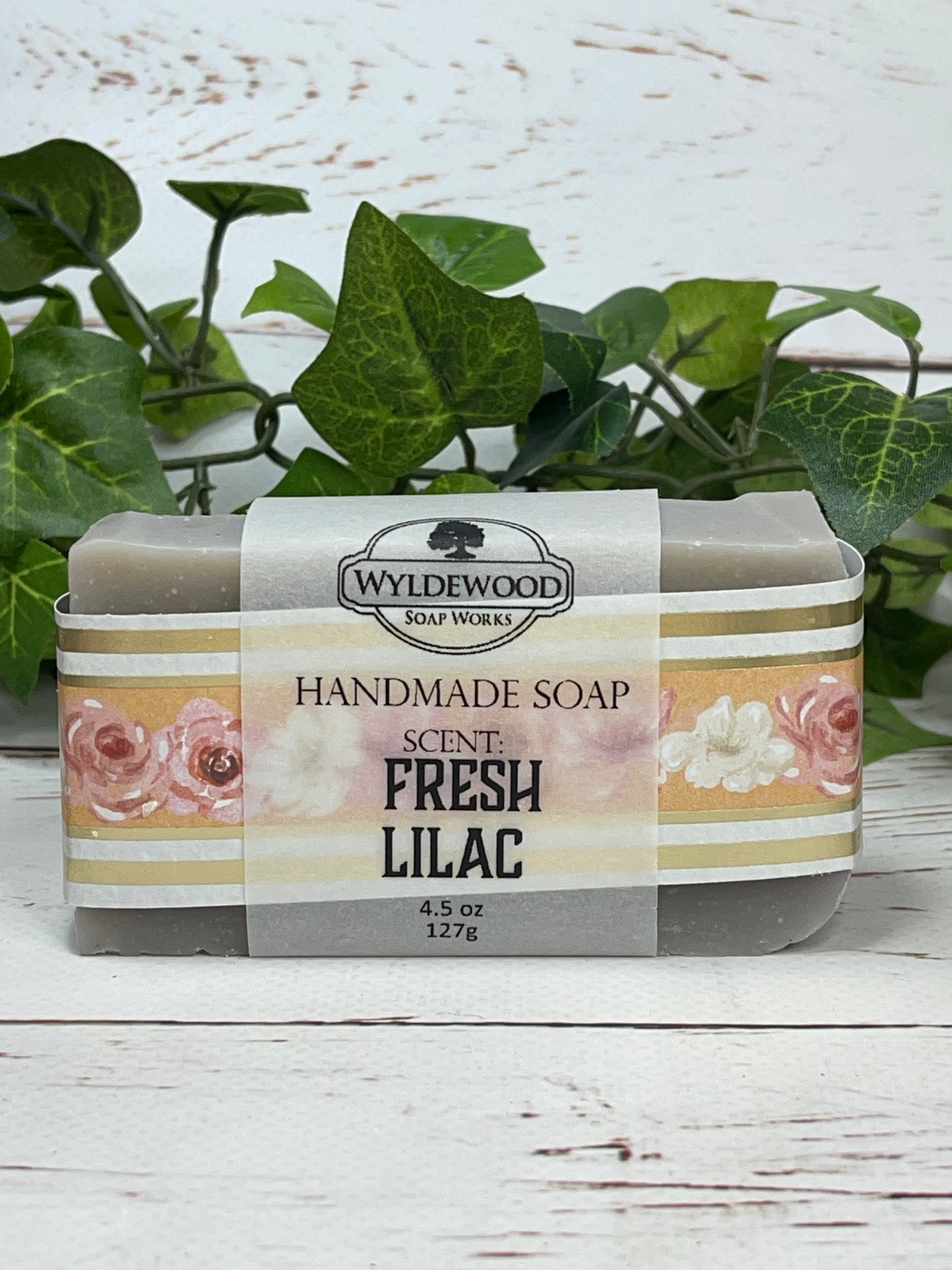 A packaged bar of Fresh Lilac scented soap with a label showing the brand name 'Wyldwood' and an image of pink lilac flowers. The soap is displayed on a white surface with a green leafy background.